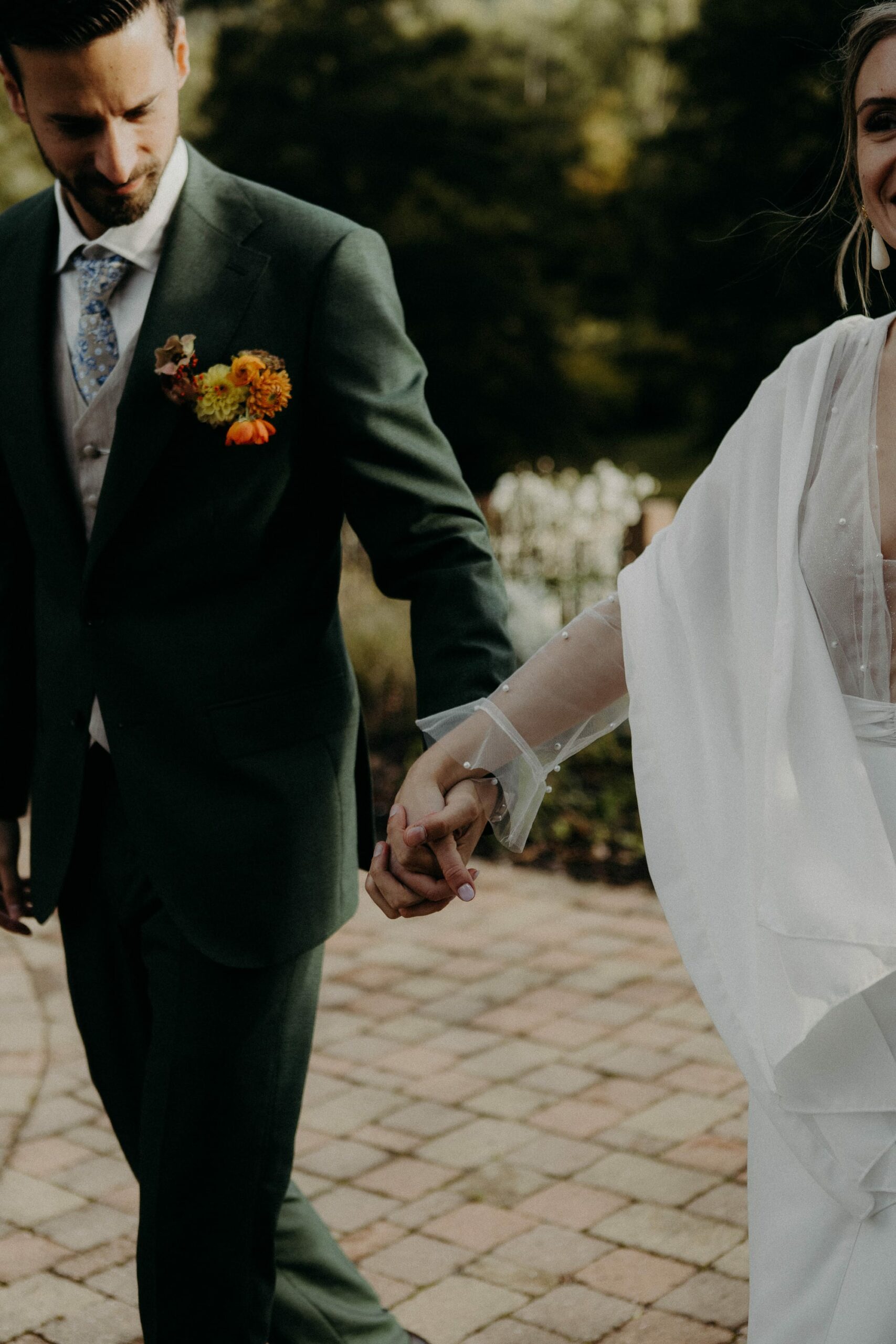 photo d'un couple de mariés se serrant la mains avec des couleurs automnales